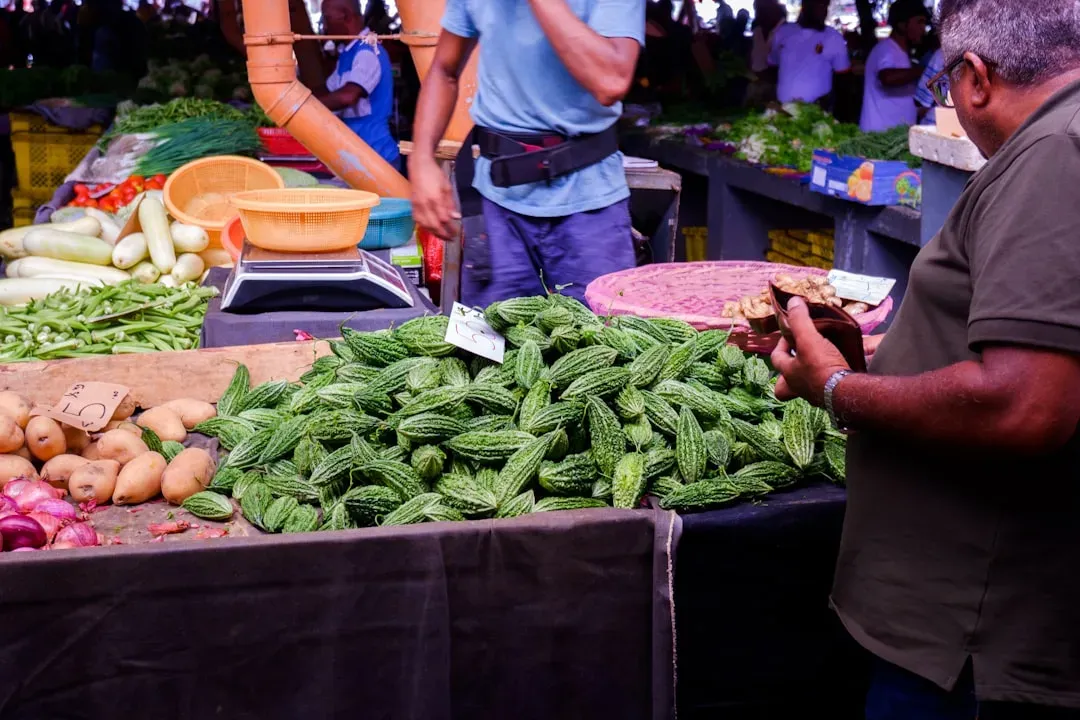 Farmers market stand selling fresh aquaponics-grown lettuce, herbs, and vegetables with customers browsing, demonstrating dir